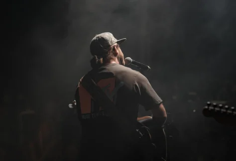 the back of a musician playing guitar on stage