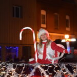 A woman in the back of a truck during a holiday parade