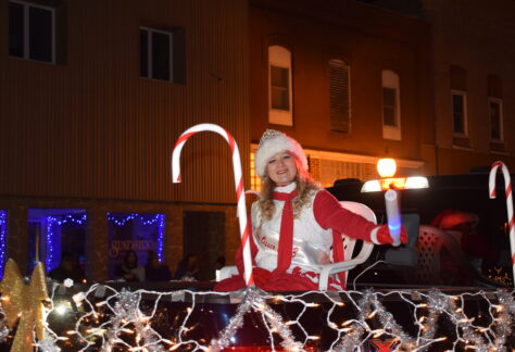 A woman in the back of a truck during a holiday parade