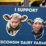 children putting their heads through cardboard cutouts of cows