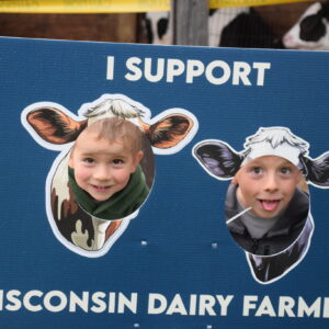 children putting their heads through cardboard cutouts of cows