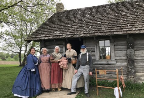 Five people dressed in era clothes from the time of Laura Ingalls Wilder's childhood