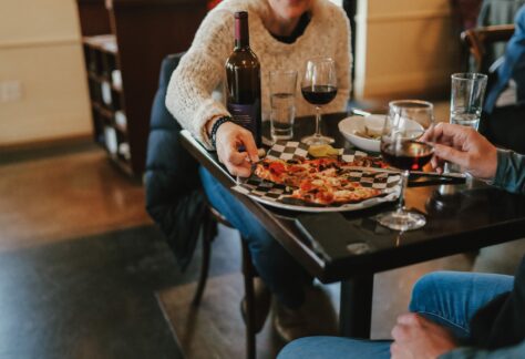 a couple enjoys pizza and wine