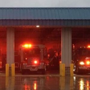 A tow of fire trucks lit up in their garage