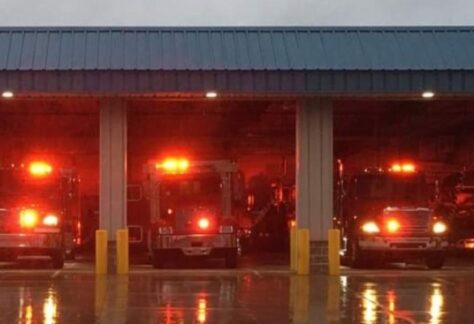 A tow of fire trucks lit up in their garage
