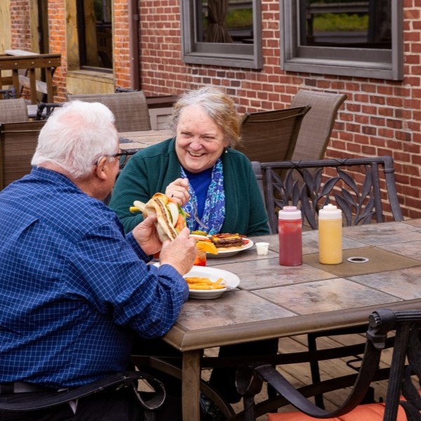 A retired couple dining on an outdoor patio.