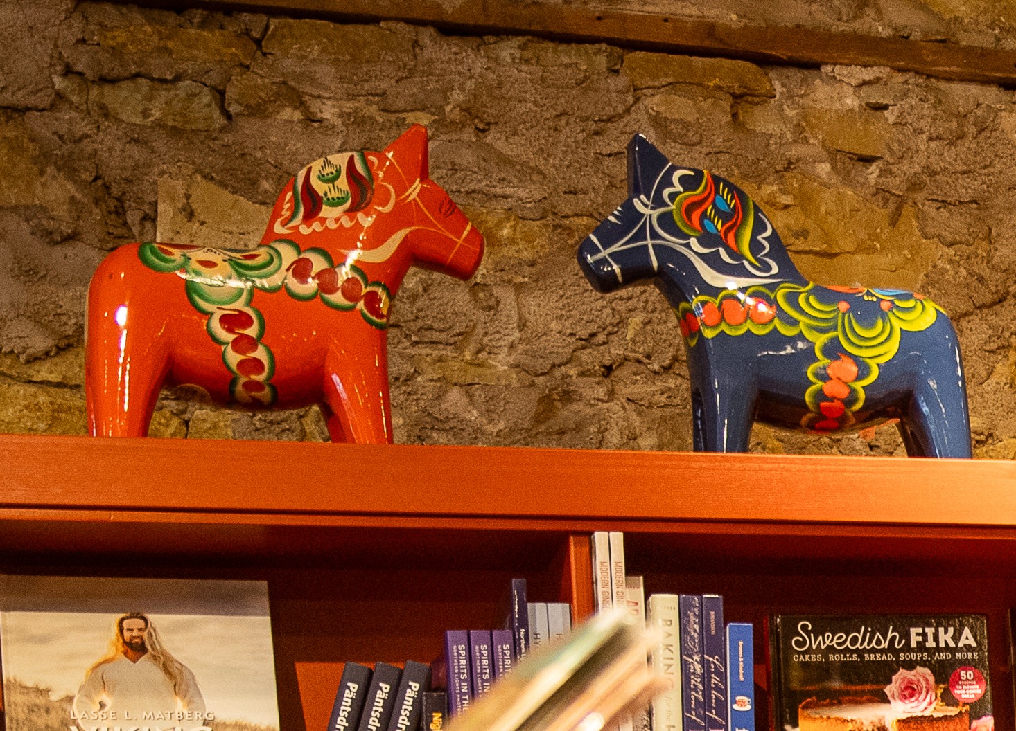 Two brightly colored Scandinavian horse sculptures